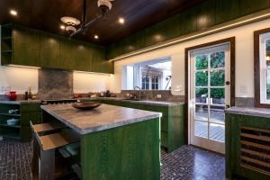 Una cocina grande con gabinetes verdes y una isla grande. en Whimsical Los Feliz House - Pool - Fire Pit - Dogs OK, en Los Ángeles