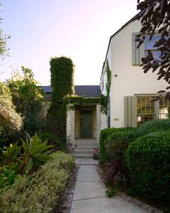una casa blanca con un camino que conduce a la puerta principal en Whimsical Los Feliz House - Pool - Fire Pit - Dogs OK, en Los Ángeles