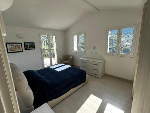 a bedroom with a bed and a desk and windows at House in Paradise in Moneglia +19 photos