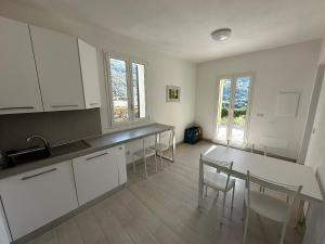 a kitchen with white cabinets and a table and chairs at House in Paradise in Moneglia