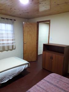 a bedroom with a bed and a mirror and a door at Cabañas La FLorencia in Magdalena +22 photos