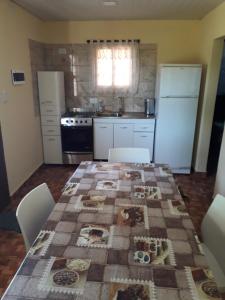 a kitchen with a table with a quilt on it at Cabañas La FLorencia in Magdalena