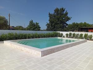 a pool on a patio with a tile floor and anergynergynergyploadpload at Al Settimo Chilometro in Gioia del Colle