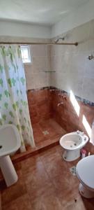 Un baño con ducha, lavabo y bañera. en Cabana Cecilia, en Villa Icho Cruz 2 fotos más