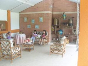 three girls sitting in a room with a table and chairs at Casa con Piscina cerca a Neiva 1 in Palermo