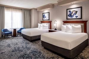 a hotel room with two beds and a table and chairs at Harrah's Joliet, A Caesars Destination in Joliet +60 photos