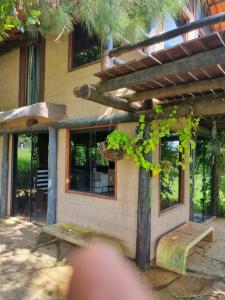 a building with a pergola and a bench in front of it at Vista Bella HostHouse 2 in Brasilia