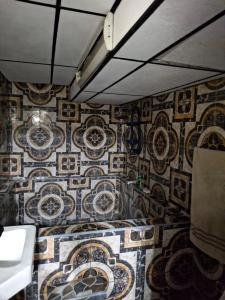 Un baño con mosaicos en la pared de una habitación. en Alquileres El Ángel, en San Salvador