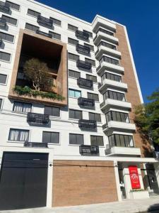a tall white building with a window at Flat moderno Garagem AR cond Jardim Amália VR in Volta Redonda