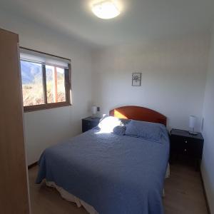 a bedroom with a blue bed and a window at Asclepia lodge spa in Quebrada Escobares