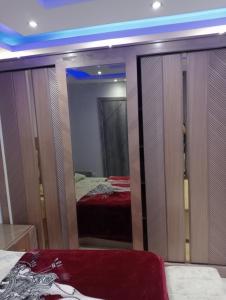 a reflection of a bedroom with a bed and a mirror at شقه فندقيه اول سكن in Cairo
