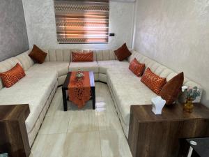 a living room with a large couch and a table at Appartement INES Saidia in Saïdia