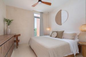 a white bedroom with a bed and a mirror at Kune in Tulum +76 photos