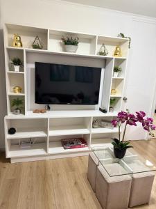 a white entertainment center with a flat screen tv at Descanso y naturaleza en Papudo in Papudo