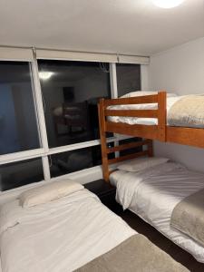 two bunk beds in a room with a window at Descanso y naturaleza en Papudo in Papudo
