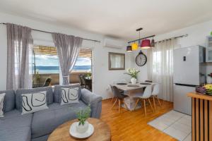 a living room with a gray couch and a table at Apartments with parking space Duce, Omis - 4663 in Duće