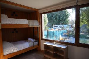 サン・カルロス・デ・バリローチェにあるGuti Andino Hostel Boutiqueのベッドルーム(二段ベッド1組、大きな窓付)