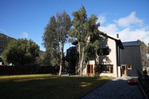 サン・カルロス・デ・バリローチェにあるGuti Andino Hostel Boutiqueの前に木がある家