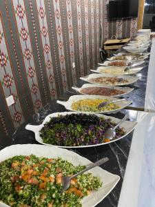 una fila de platos de comida en un buffet en Darina Rum Camp, en Wadi Rum 33 fotos más