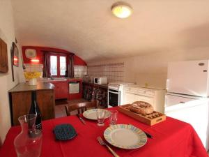 a kitchen with a table with a red table cloth at Gîte chaleureux entre festivals, nature et confort avec wifi à Jullianges - FR-1-582-237 in Jullianges