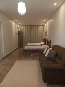 a living room with a couch and two beds at Lindo Loft no centro de Assis in Assis