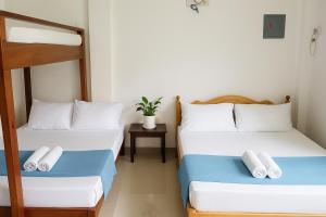a room with two bunk beds and a table at Yayay Siargao - Generator & Starlink in General Luna