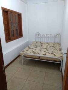 a small bed in a room with a window at Sítio Cantinho da Natureza in Piraí