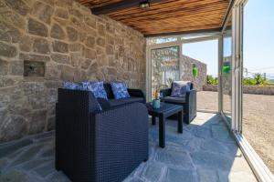 a stone walled patio with two chairs and a table at House Scaena in Jadranovo