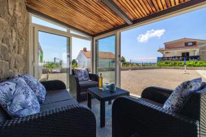 a screened in porch with two couches and a table at House Scaena in Jadranovo