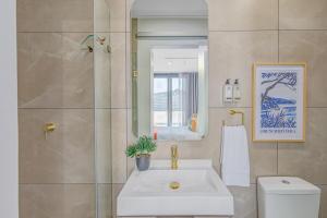 a bathroom with a sink and a toilet and a mirror at One Rosebank- 2 bedroom PentHaus on sixth in Johannesburg +21 photos