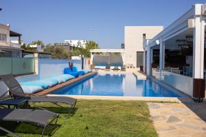 a swimming pool with lounge chairs and a building at Blue Point Hotel Yalikavak in Yalıkavak
