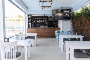 a restaurant with white tables and chairs and a kitchen at Blue Point Hotel Yalikavak in Yalıkavak