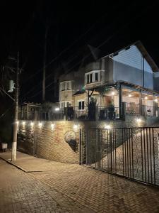 a fence with lights in front of a building at Casa Aconchegante em São Chico in São Francisco de Paula