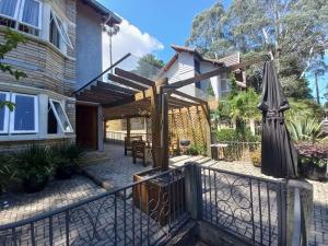 a patio with an umbrella and a fence at Casa Aconchegante em São Chico in São Francisco de Paula