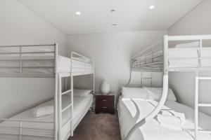 a bedroom with two bunk beds and a desk at Moritz 1 in Mount Hotham