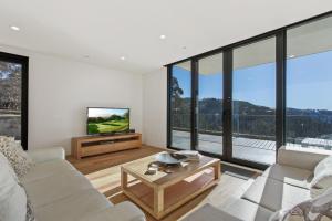 a living room with a couch and a tv at Moritz 1 in Mount Hotham