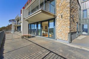 a deck with glass doors and a building at Moritz 1 in Mount Hotham