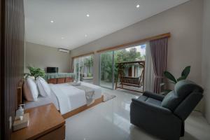 a bedroom with a large bed and a chair at Villa Lumiere - 3BR Luxury Villa with Private Pool in Seminyak +28 photos