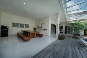 a large living room with a wooden table and bench at Villa Lumiere - 3BR Luxury Villa with Private Pool in Seminyak