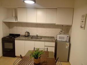 a small kitchen with a table and a microwave at Alojamiento Guemes in San Fernando del Valle de Catamarca +5 photos