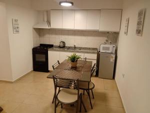 a kitchen with a table and chairs and a refrigerator at Alojamiento Guemes in San Fernando del Valle de Catamarca