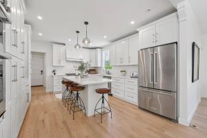 eine Küche mit weißen Schränken und einem Edelstahlkühlschrank in der Unterkunft NEW! Heritage Retreat in the heart of Stillwater in Stillwater