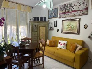 a living room with a yellow couch and a table at Nel cuore del Salento in Montalbano