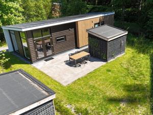 a small cabin with a bench in the grass at Luxury holiday home surrounded by water in Sint Nicolaasga