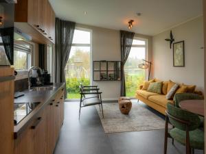a kitchen and a living room with a couch at Luxury holiday home surrounded by water in Sint Nicolaasga