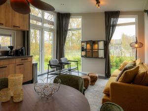 a kitchen and living room with a table and chairs at Luxury holiday home surrounded by water in Sint Nicolaasga