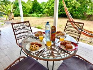 una mesa de cristal con comida y bebida en el patio en Villa Tea Free, en Anse-Bertrand 14 fotos más