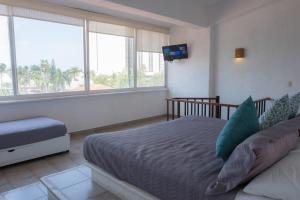 une chambre avec un lit, une télévision et des fenêtres dans l'établissement Apt with Jacuzzi Ixtapa Zihuatanejo 3 BR, à Ixtapa 63 autres photos
