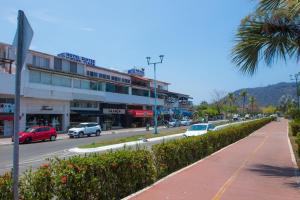 une rue de la ville avec des voitures garées sur la route dans l'établissement Apt with Jacuzzi Ixtapa Zihuatanejo 3 BR, à Ixtapa
