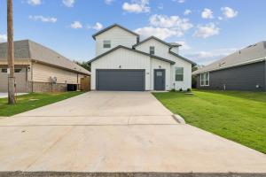 a large white house with a garage at Hi-Tech Haven by Hospital & Lake in Granbury